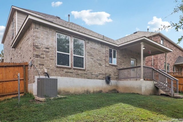 back of house with a lawn and central AC