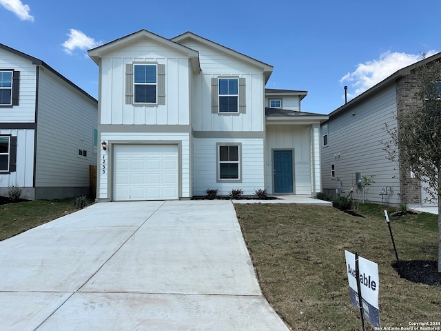 view of front of home with board and batten siding, an attached garage, driveway, and a front yard