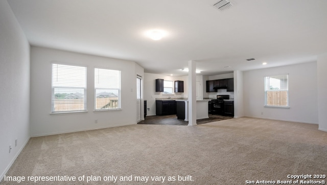 unfurnished living room with light colored carpet