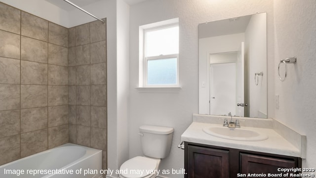 full bathroom featuring tiled shower / bath, toilet, and vanity