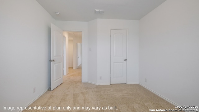 unfurnished bedroom with a closet and light carpet