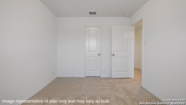 unfurnished bedroom featuring light carpet and a closet