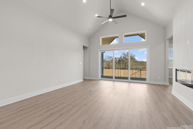 unfurnished living room with ceiling fan, high vaulted ceiling, and light hardwood / wood-style floors