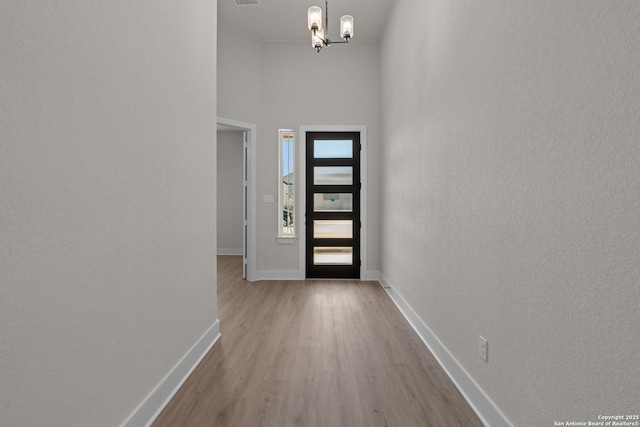 entrance foyer with an inviting chandelier and light hardwood / wood-style flooring