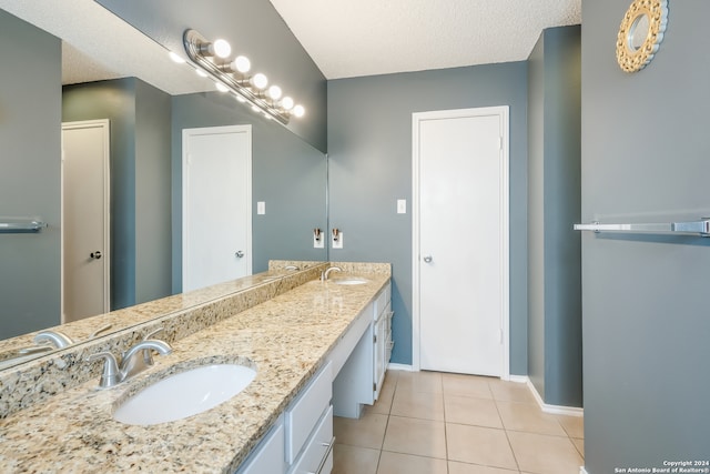 bathroom with a textured ceiling, vanity, and tile patterned floors