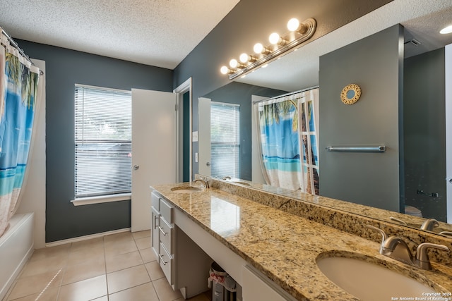 bathroom featuring vanity, a textured ceiling, shower / tub combo with curtain, and tile patterned floors