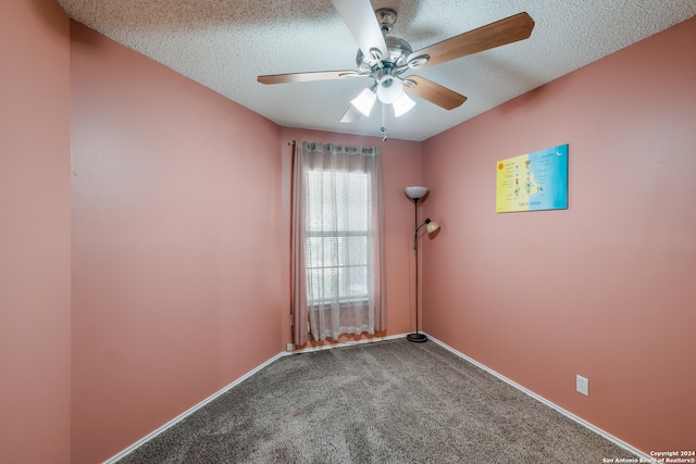 spare room featuring a textured ceiling, ceiling fan, and carpet floors