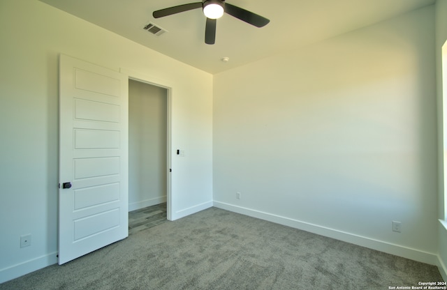 carpeted empty room featuring ceiling fan