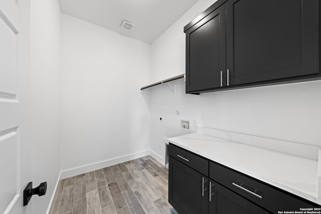 laundry area featuring hookup for a washing machine, cabinets, and light hardwood / wood-style flooring