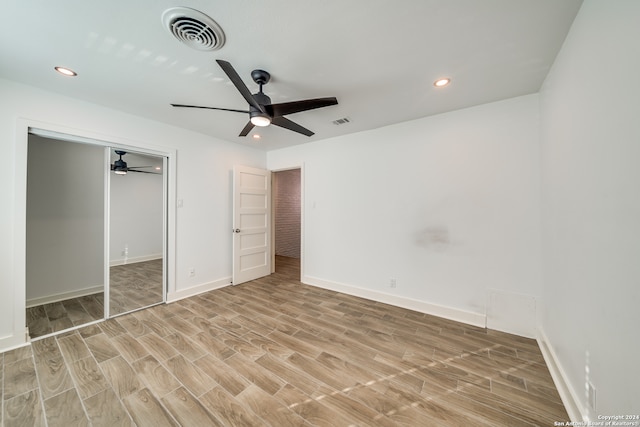 unfurnished bedroom featuring light hardwood / wood-style flooring, ceiling fan, and a closet