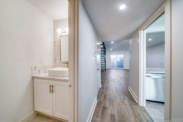 hallway with sink and light hardwood / wood-style floors