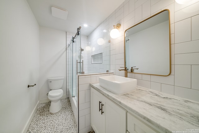 bathroom with tile patterned floors, walk in shower, toilet, tile walls, and vanity