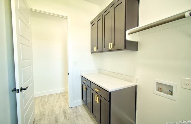 laundry room with cabinets, washer hookup, and light hardwood / wood-style flooring