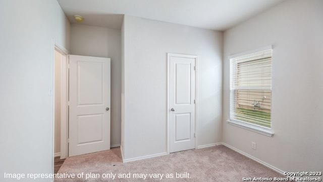 unfurnished bedroom featuring light colored carpet