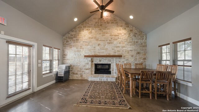 dining space featuring ceiling fan, a fireplace, and high vaulted ceiling