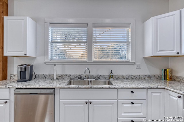 kitchen with dishwasher, light stone counters, sink, and white cabinetry