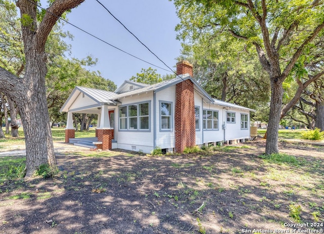 view of side of home featuring covered porch