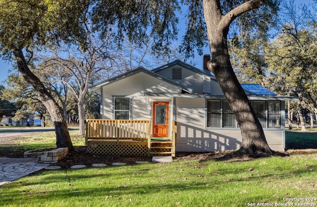 bungalow-style home featuring a wooden deck and a front yard