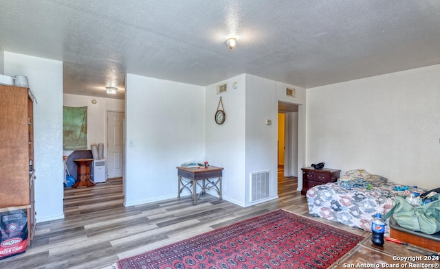 bedroom featuring wood-type flooring and a textured ceiling