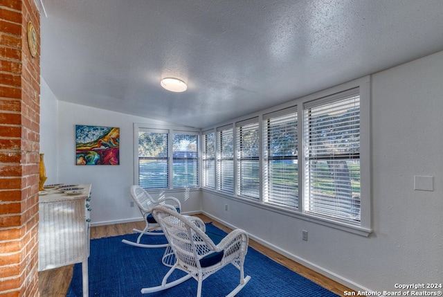 interior space with vaulted ceiling, a textured ceiling, and wood-type flooring