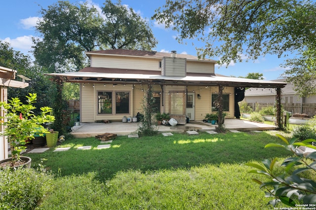 back of house with a lawn and a patio