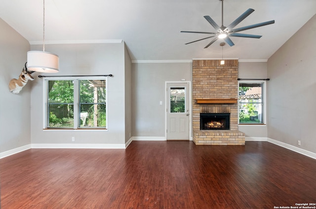 unfurnished living room featuring ceiling fan, dark hardwood / wood-style floors, crown molding, and a brick fireplace