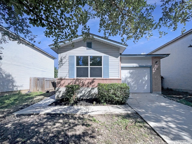 ranch-style house featuring concrete driveway, an attached garage, and fence