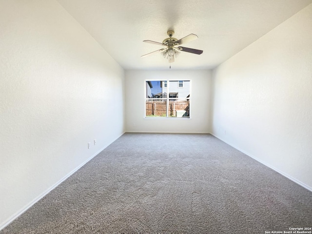 carpeted empty room featuring baseboards and ceiling fan