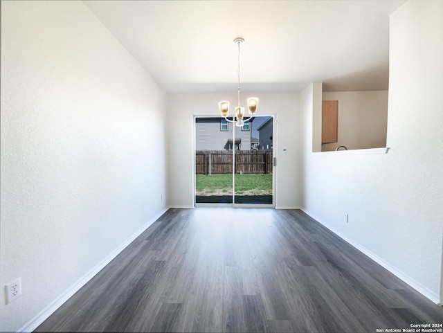 empty room with dark wood finished floors, baseboards, and a chandelier