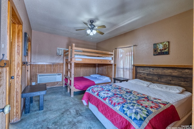 carpeted bedroom featuring a textured ceiling, a wall mounted AC, and ceiling fan