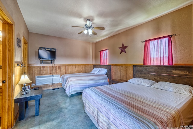 carpeted bedroom with wood walls, ceiling fan, and a textured ceiling