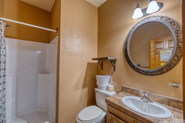 bathroom with vanity, toilet, and walk in shower