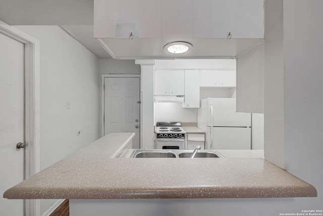 kitchen featuring under cabinet range hood, white appliances, white cabinets, and a sink