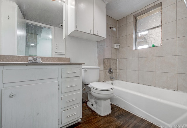 bathroom featuring vanity, toilet, wood finished floors, and tub / shower combination