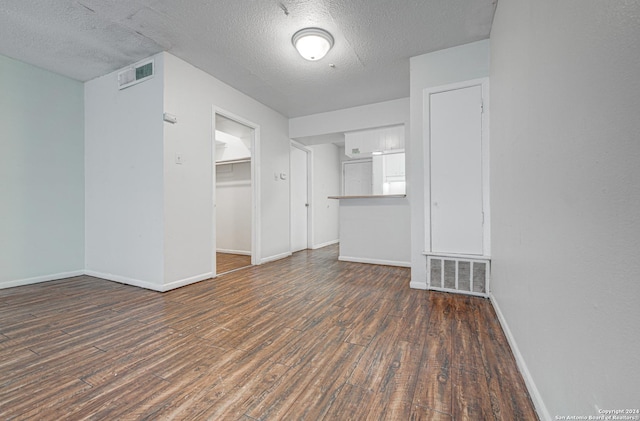 spare room featuring wood finished floors, visible vents, and baseboards