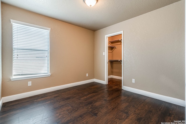 unfurnished room featuring dark hardwood / wood-style flooring and a textured ceiling