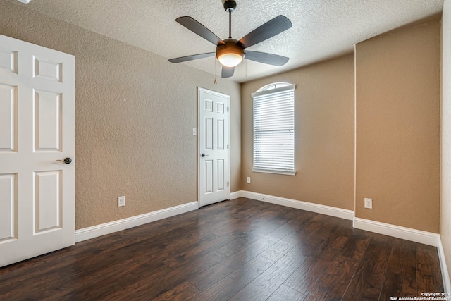 spare room with dark wood-type flooring, a textured ceiling, and ceiling fan