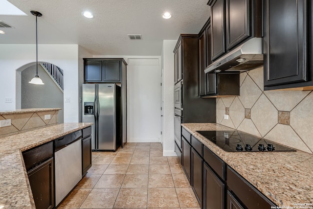 kitchen featuring a textured ceiling, pendant lighting, appliances with stainless steel finishes, light stone counters, and light tile patterned flooring