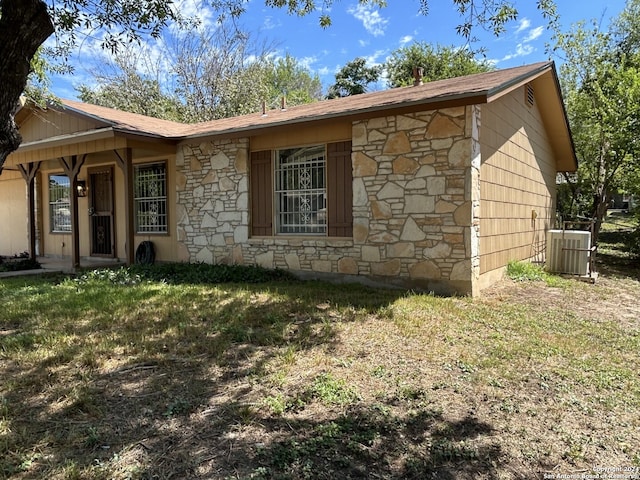 view of side of property featuring a yard and central air condition unit