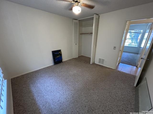 unfurnished bedroom with a closet, a textured ceiling, ceiling fan, and carpet