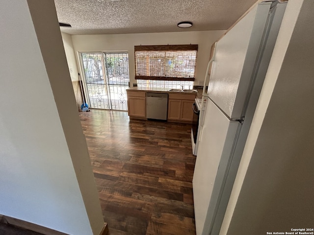 kitchen with white appliances, dark hardwood / wood-style flooring, and a textured ceiling