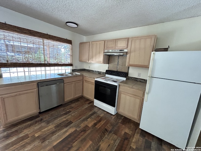 kitchen with a textured ceiling, dark hardwood / wood-style floors, white appliances, light brown cabinetry, and tile countertops