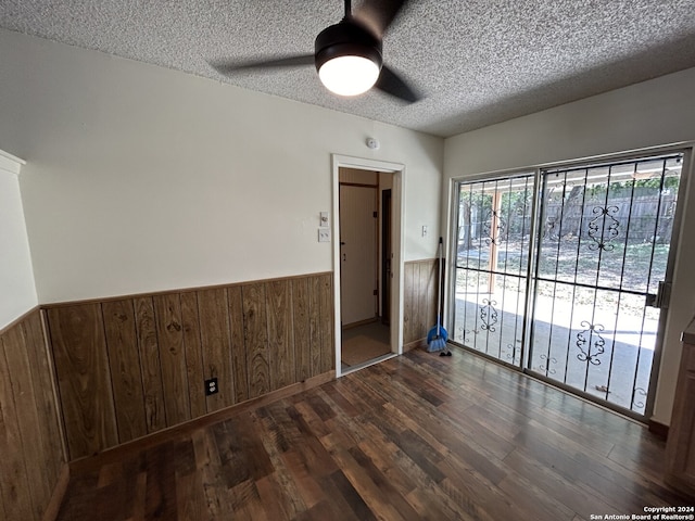 empty room with ceiling fan, hardwood / wood-style flooring, and a textured ceiling