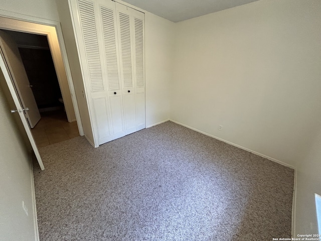 unfurnished bedroom featuring a closet and carpet floors