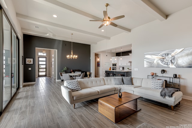 living room featuring ceiling fan with notable chandelier, wood-type flooring, and beam ceiling