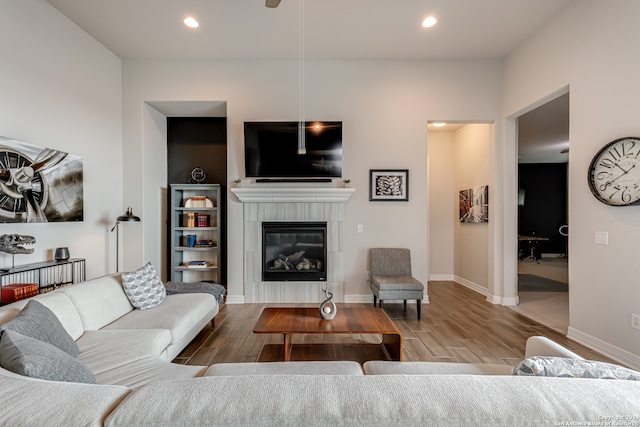 living room with hardwood / wood-style floors and a tiled fireplace