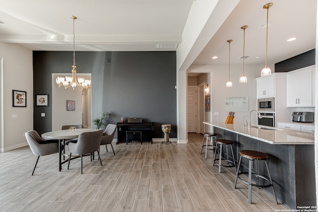 dining room featuring a chandelier, light hardwood / wood-style floors, and sink