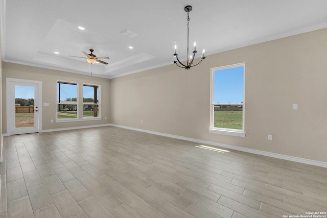 empty room featuring ceiling fan with notable chandelier, ornamental molding, light hardwood / wood-style flooring, and a tray ceiling