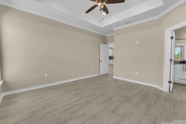 interior space with light wood-type flooring, a tray ceiling, ceiling fan, and crown molding