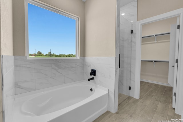 bathroom featuring hardwood / wood-style flooring and shower with separate bathtub